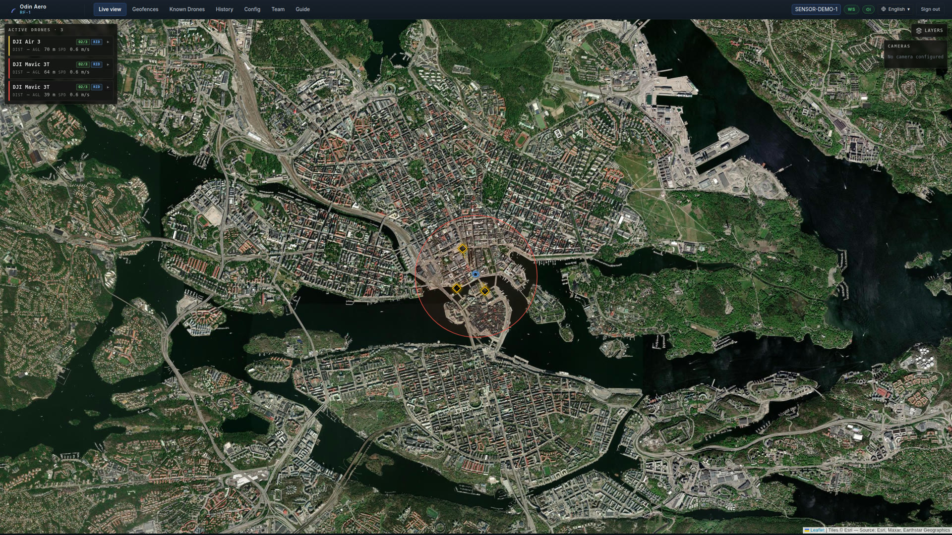 Odin Aero live operations view: satellite map of Stockholm with three tracked drones, telemetry cards and a geofenced alarm zone.